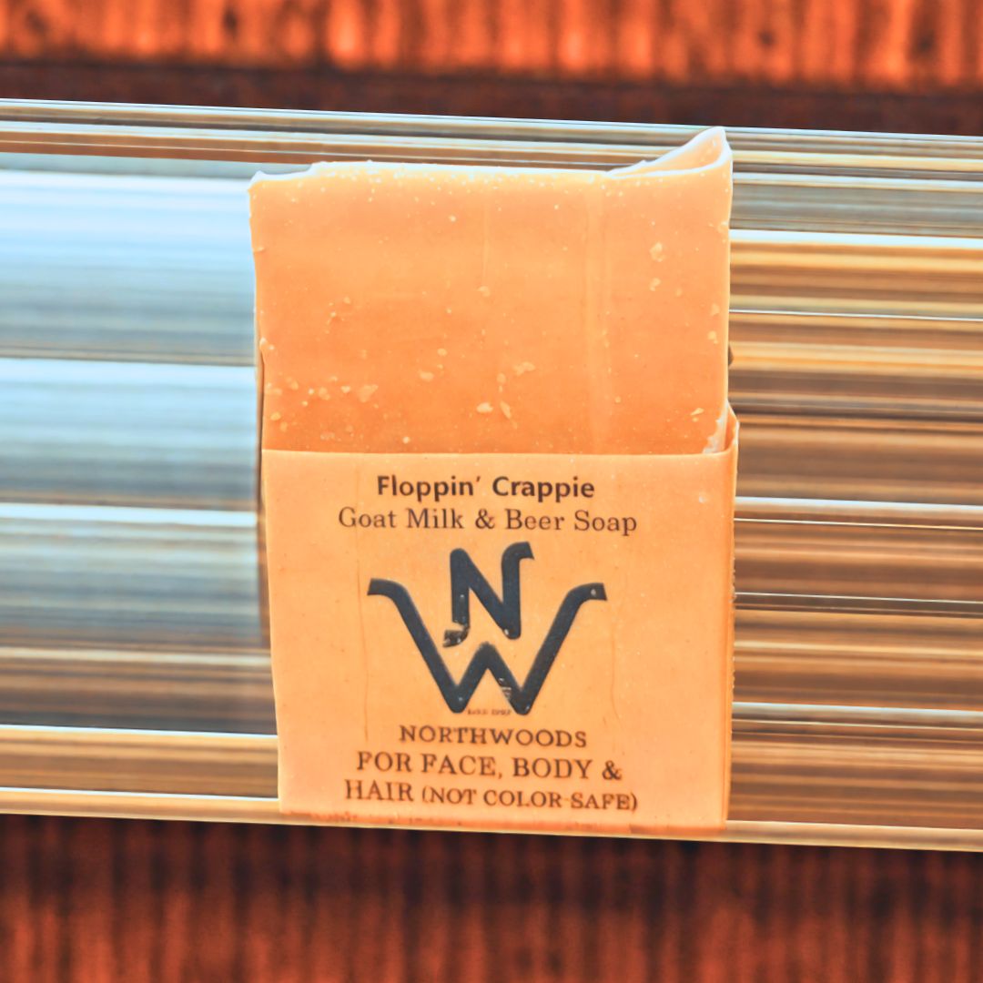 A bar of 'Floppin' Crappie' Goat Milk & Beer Soap with packaging that includes the product name and the Northwoods Brewpub logo.