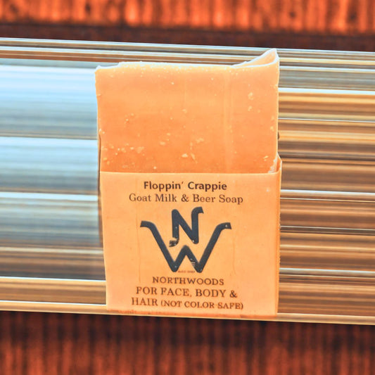 A bar of 'Floppin' Crappie' Goat Milk & Beer Soap with packaging that includes the product name and the Northwoods Brewpub logo.