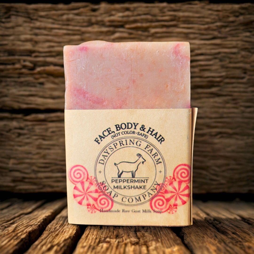 Bar of soap with a red and white design on a wooden surface, featuring Dayspring Farm Soap Company branding.